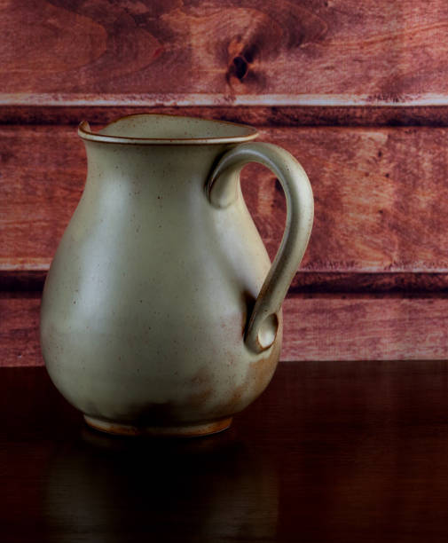 istock Old Earthenware Wine Jug on a Wooden Shelf 1415765516