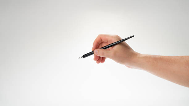 istock A woman's right hand holds a pen for calligraphy and writing gesture to write 1415765594