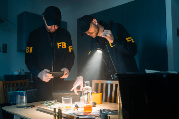 istock FBI agents in uniform at the crime scene with a flashlight during investigation working with physical evidences on a table 1415766694