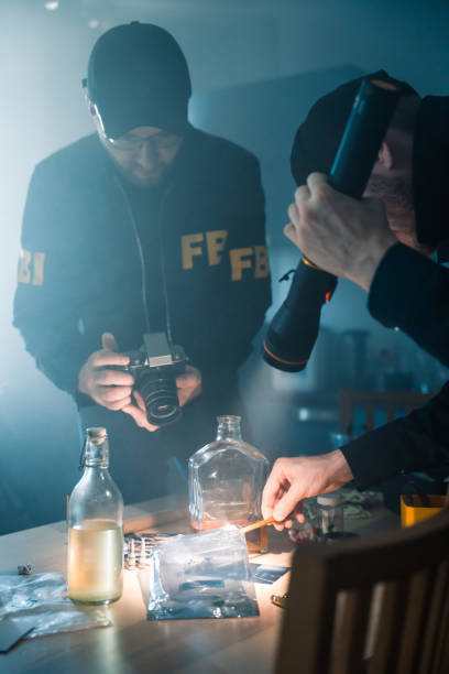 istock FBI agents in uniform taking pictures of physical evidences on a table with camera lighting those with a flashlight 1415767300