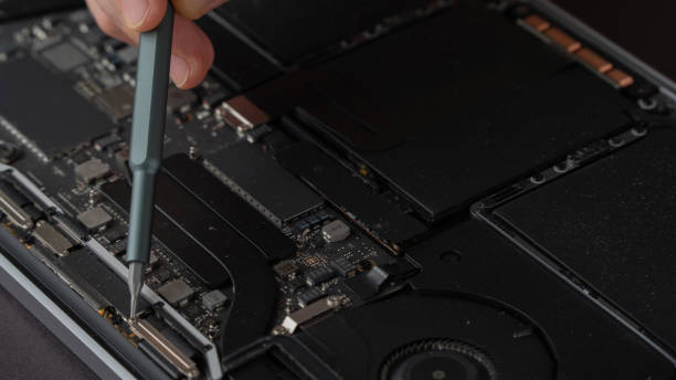 istock Repair Laptop Service Hand with Screwdriver Removes Computer Back Cover 1415770437