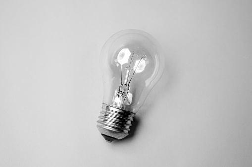 Old style light bulb on a gray background.The bulb stands independently on the ground.Electricity,energy.