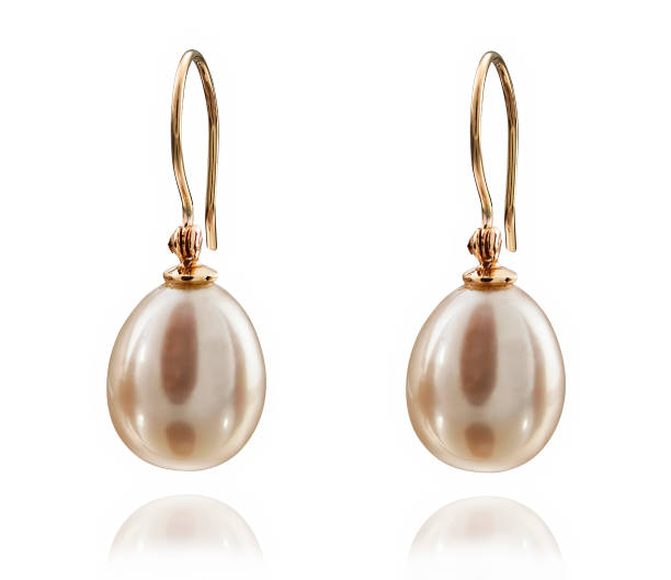 Golden earrings with white pearl isolated on white background.