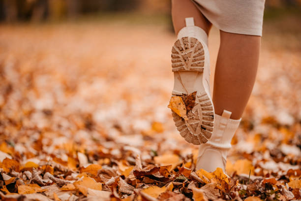 Conceptual legs in shoes on autumn leaves