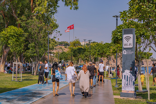 10 July 2022, Antalya, Turkey: Bicycle and a pedestrian path on the Antalya embankment. People are walking and enjoying the weather and the weekend