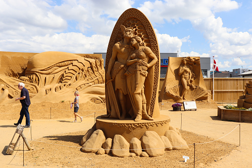 British Columbia, Canada - July 14, 2015: Tourists and locals come to see the winning sand sculpture of Batmand and Joker at the annual sand sculpture competition in Parksville, Vancouver Island