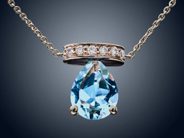 Golden necklace with Aquamarine gemstone isolated on grey stock photo