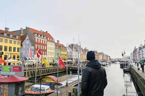 Copenhagen, Denmark; January 17, 2017: Young man in Nyhavn port in Copenhagen