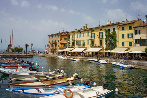 Peschiera del Garda, Italy - June 27, 2022: Touristic harbor at Peschiera del Garda along the cycleway of Mincio river, Verona province, Veneto, Italy, at summer
