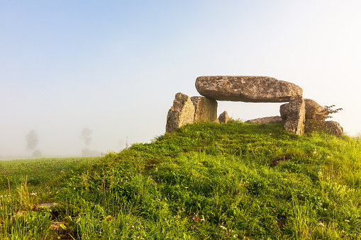 Stone age passage grave on a hill with mist