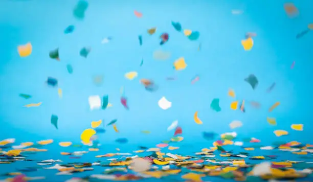 Colorful confetti in front of blue background