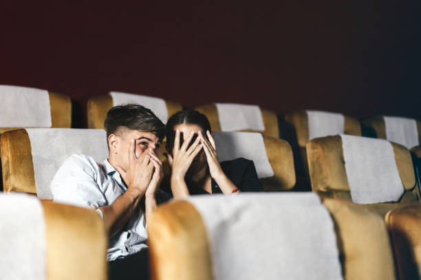 caucasian white man and woman see thriller movie. - audience surprise movie theater shock imagens e fotografias de stock
