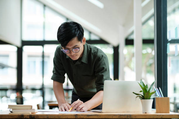istock Young asian business man or student working online on computer laptop. 1415788910