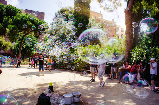 6th June, 2022 - Street performer creating huge bubble art for enthralled passing tourists in the centre of Barcelona, Spain