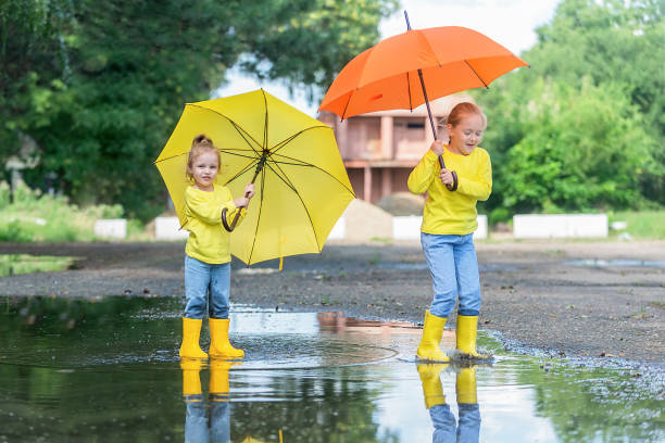 istock children have fun after the rain, run through the puddles 1415791123