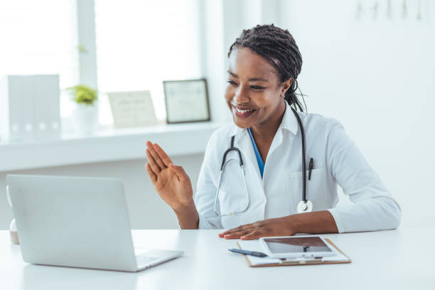 istock Doctor sitting at a desk, using a laptop for a video call 1415794644