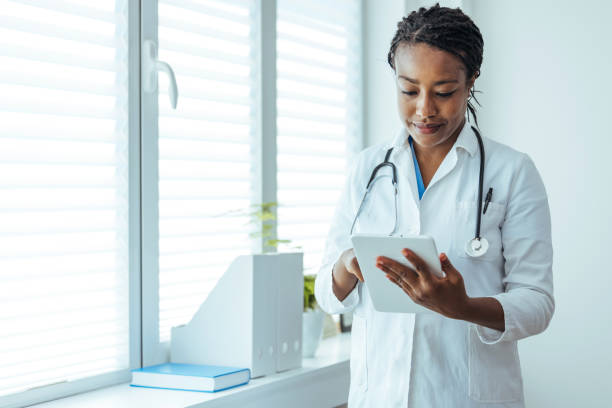 istock Happy young female doctor holding tablet computer 1415794741