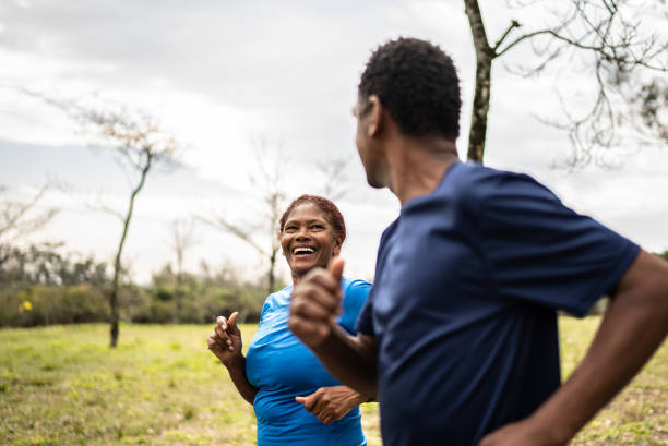 Senior couple walking in a park Senior couple walking in a park body positive couple stock pictures, royalty-free photos & images