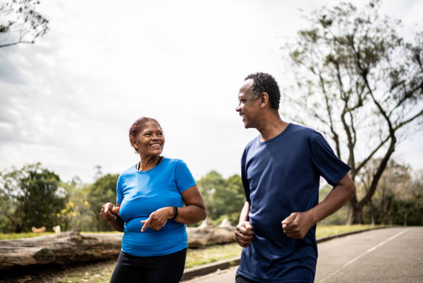 Senior couple walking in a park Senior couple walking in a park body positive couple stock pictures, royalty-free photos & images