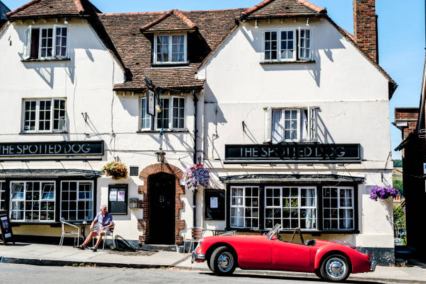 Red Open Top Classic Sports Car Parked Outside A Tradition English Pub Dorking, Surrey Hills, London UK, July 07 2022, Red Open Top Classic Sports Car Parked Outside A Tradition English Pub surrey hotel southeast england england stock pictures, royalty-free photos & images