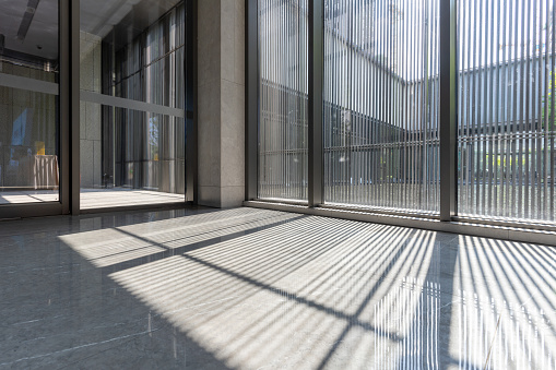 The light and shadow formed by the sunlight on the ceramic floor through the glass wall