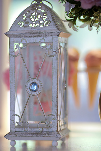 White antique candle lantern centerpiece at wedding reception dinner setting