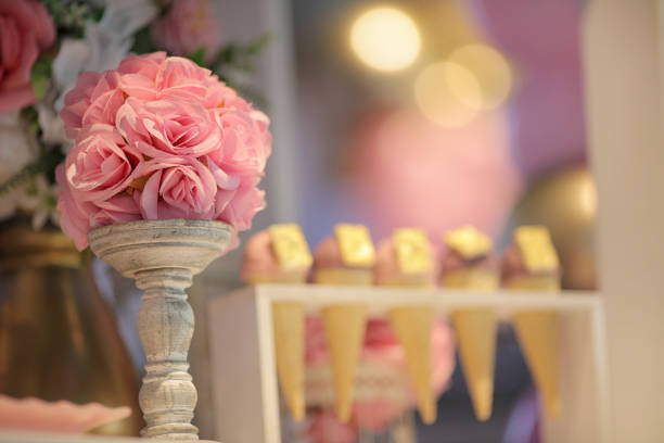 Artificial flower in pot above wooden table and ice cream as background