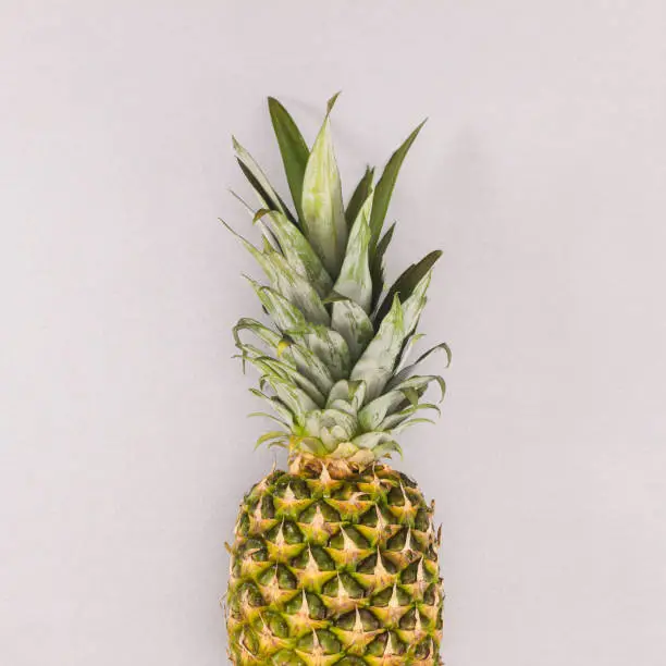 Photo of Fresh ripe pineapple on grey backgorund. Flat lay. Summer fruits concept