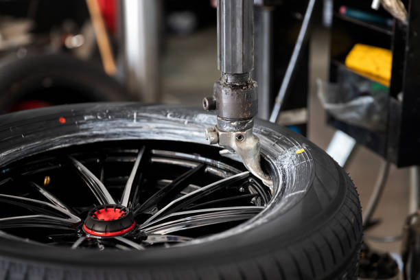 Wheel with tire on tire changing machine in auto repair service. stock photo