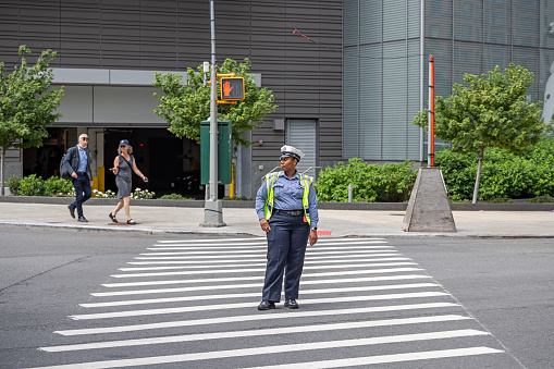 Manhattan, New York, NY, USA - July 8th 2022: African-American police wo,am regulating the traffic