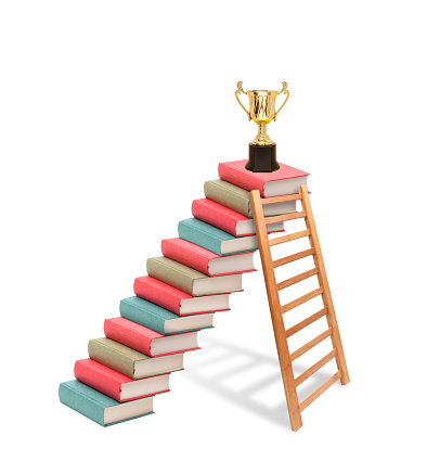 Ladder against on the book stairs and trophy isolated on white background