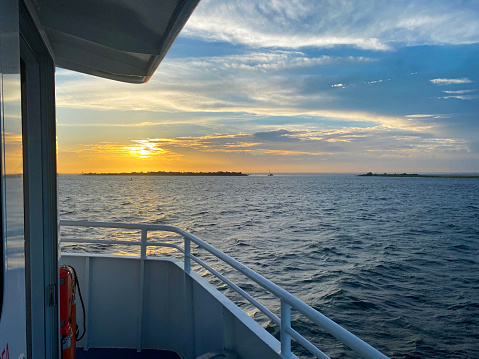 Riding on a passenger ferry boat in the Great South Bay looking at the sun setting off the ooast of Long Island.
