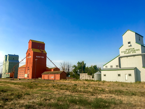 Three coloured grain elevators in Nanton, Alberta. Taken in summer 2017.