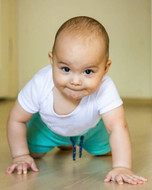 istock Sweet chubby baby learns to crawl on the floor 1415804526