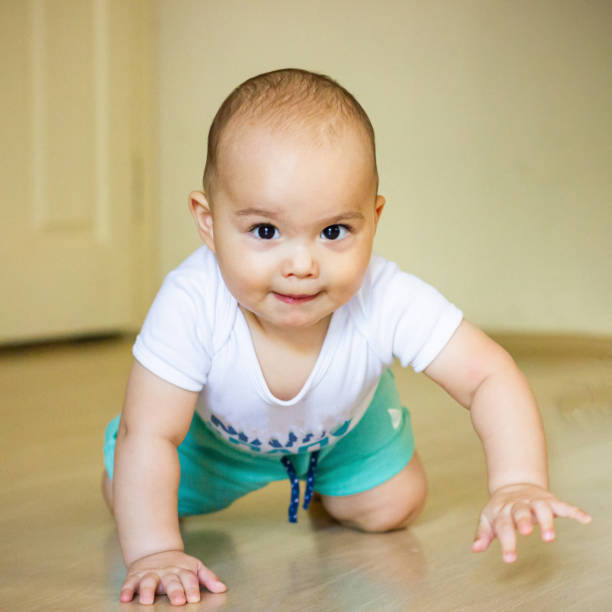 istock Sweet chubby baby learns to crawl on the floor 1415804529