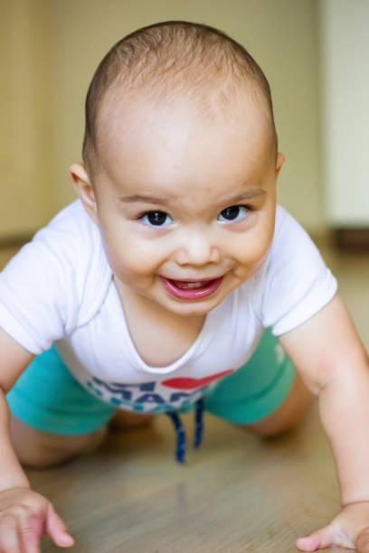 istock Sweet chubby baby learns to crawl on the floor 1415804532