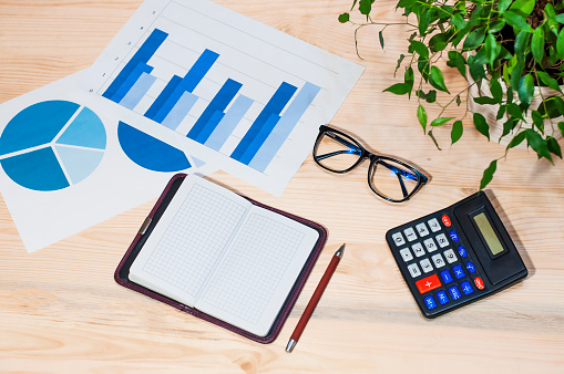 workplace, online work, calculator, glasses, notepad on a wooden table