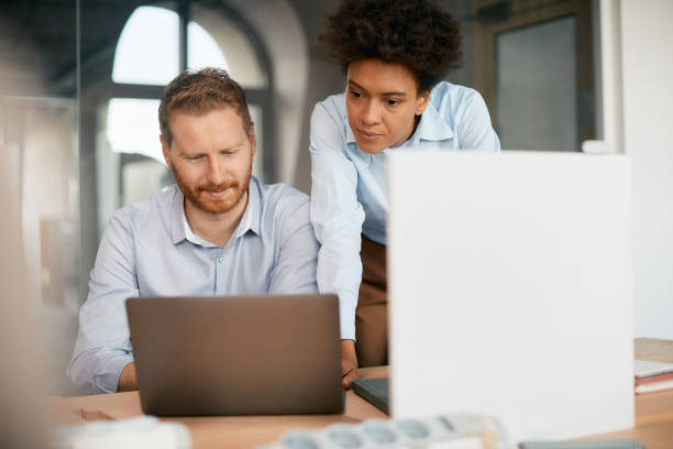 istock Two entrepreneurs cooperating while working on laptop in the office. 1415805075