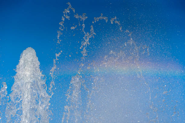 public garden fountain sprouting water with frozen effect with raibow stock photo
