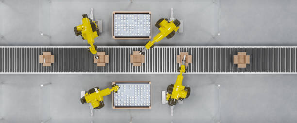 Robots at a conveyor belt packing items into cardboard packages. Top view. stock photo