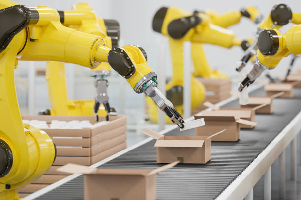 Robots at a conveyor belt packing items into cardboard packages. Detail shot. stock photo