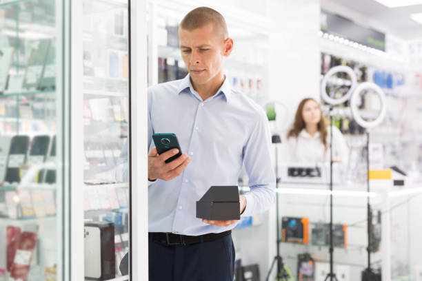 istock Man buyer choosing phone at the multimedia store 1415809806
