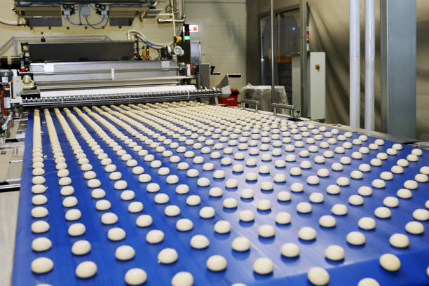 istock Close up of automated biscuit cookies shape forming machine. Selective focus. machine for making cookies in the factory. Conveyor belt with Cookie dough. 1415812527