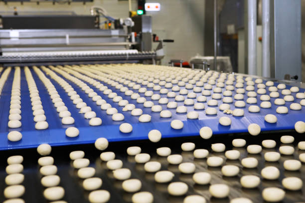 istock Close up of automated biscuit cookies shape forming machine. Selective focus. machine for making cookies in the factory. Conveyor belt with Cookie dough. 1415812555