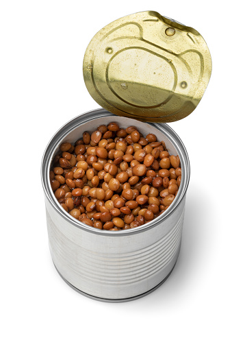Open metal can with preserved steamed brown lentils close up isolated
 on white background