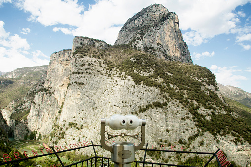 Brenta, Italy - August 12, 2022: at an altitude of 3150 in the Dolomites near Brenta is a lookout point. From there you have a beautiful view of the surroundings. Place and height are indicated on the fence with red metal letters. Binoculars have also been placed at this tourist point.