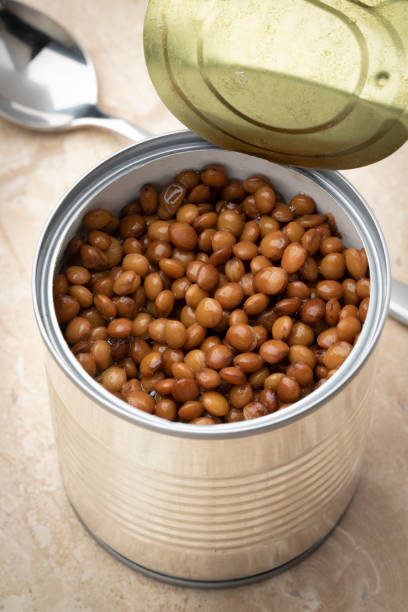 istock Open tin with preserved steamed brown lentils close up 1415814483