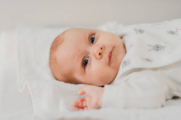 Portrait of baby with big eyes lying down on towel stock photo