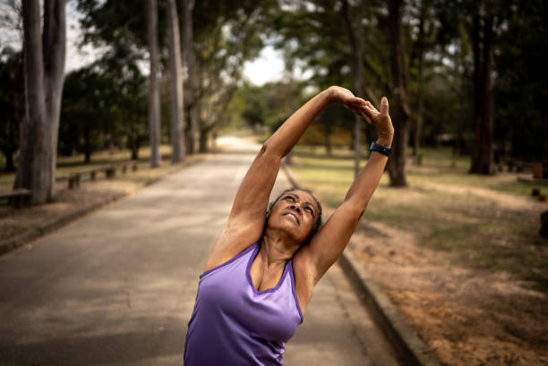 istock Senior woman stretching in a park 1415819476