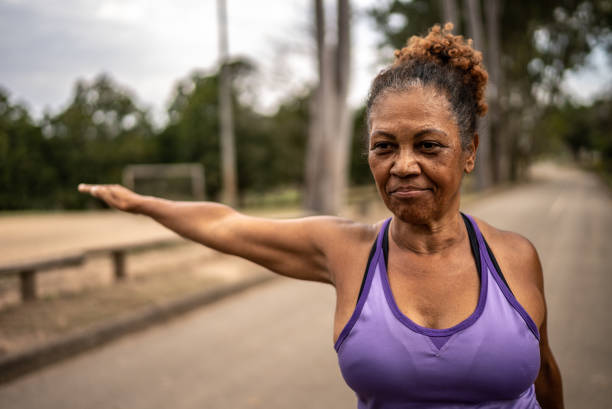 istock Senior woman stretching in a park 1415819495